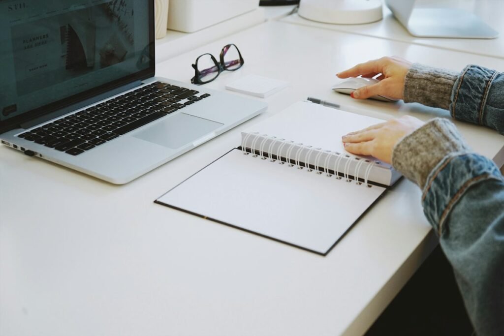 Hand resting on an open notebook