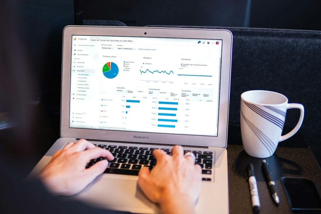 Hands on a laptop showing a marketing analytics dashboard