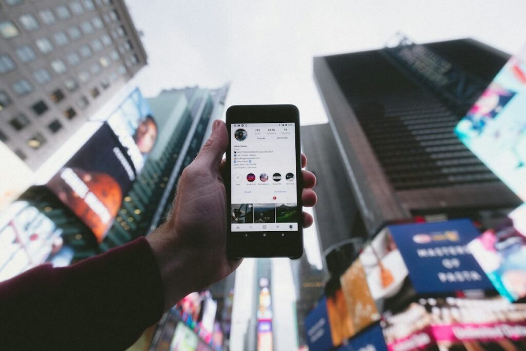 Phone showing an Instagram profile against city buildings
