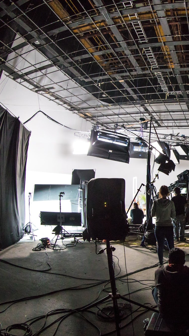 A production soundstage rigged with lighting and cameras.