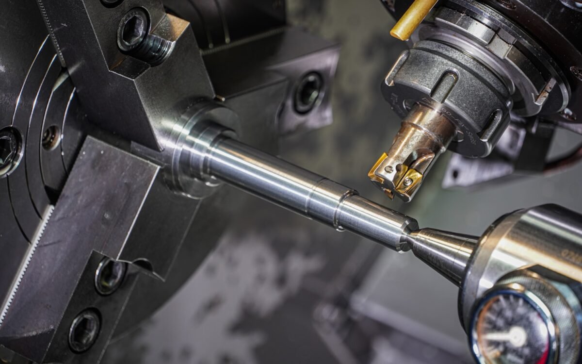 A steel component being machined on a CNC lathe.