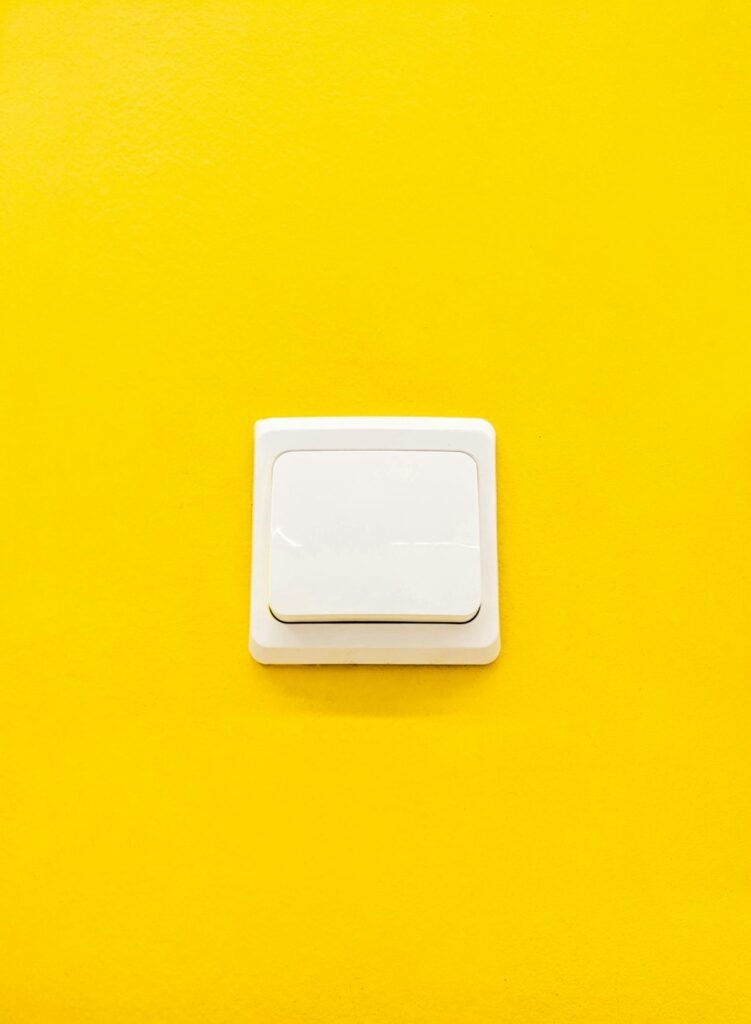 Light switch on a yellow wall